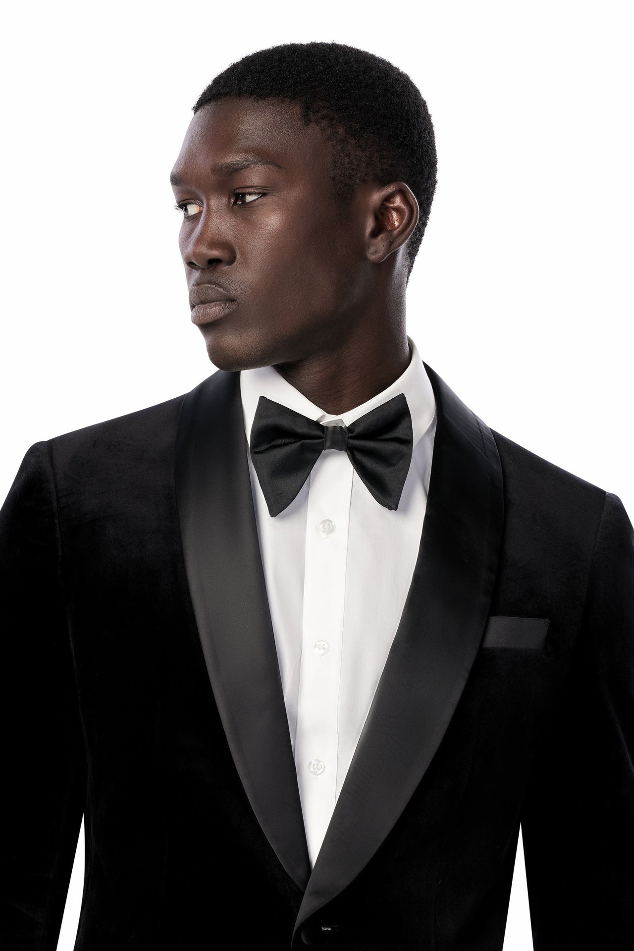 Model wearing a black velvet tuxedo with satin shawl lapels and a bow tie