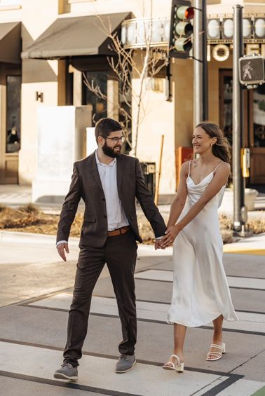 Alex M. in the Brown Sharkskin 2 Button Suit walking hand in hand with his fiancée for engagement photos