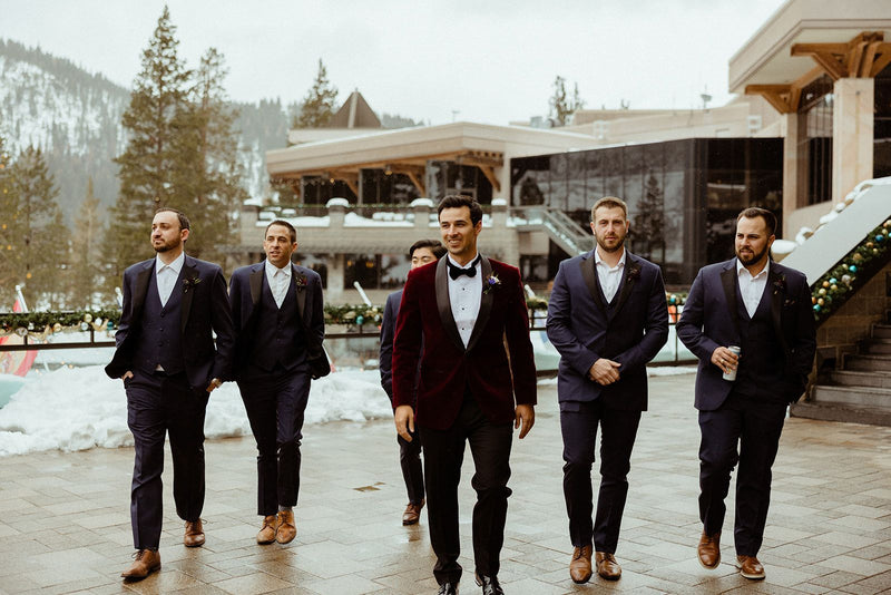 Groom Andres M. in the Burgundy Velvet Shawl Lapel Tuxedo walking with his groomsmen