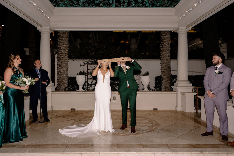 Groom Cobi C. in the Forest Green 2 Button Suit with his bride at their reception