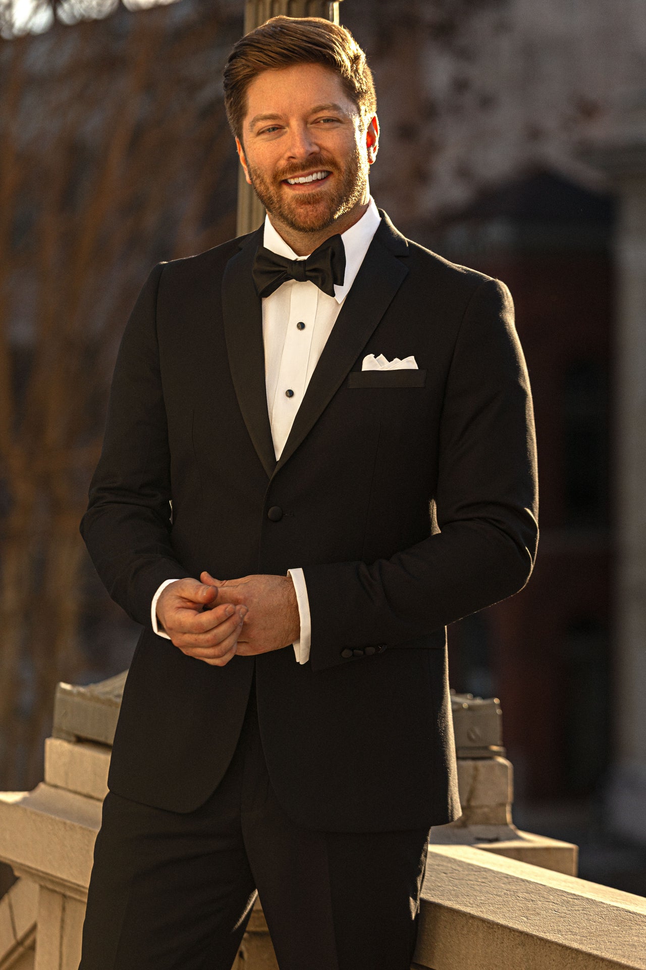 Smiling model in a black tuxedo and bow tie